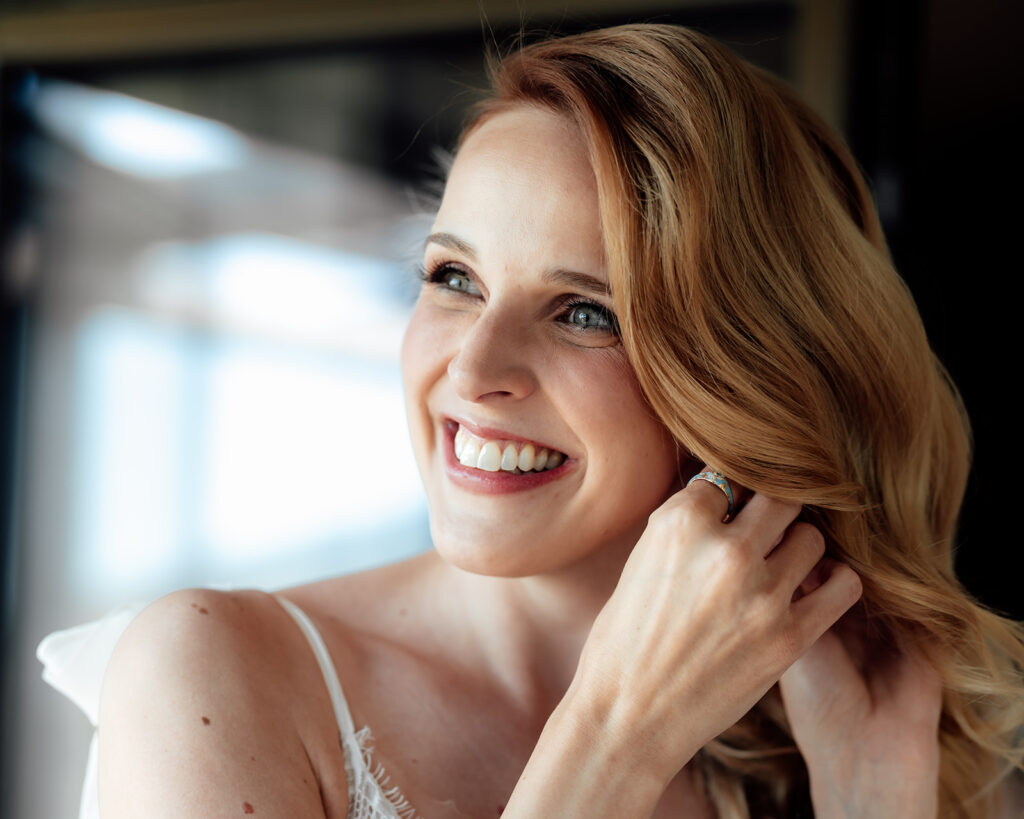 Braut steckt Ohrringe an